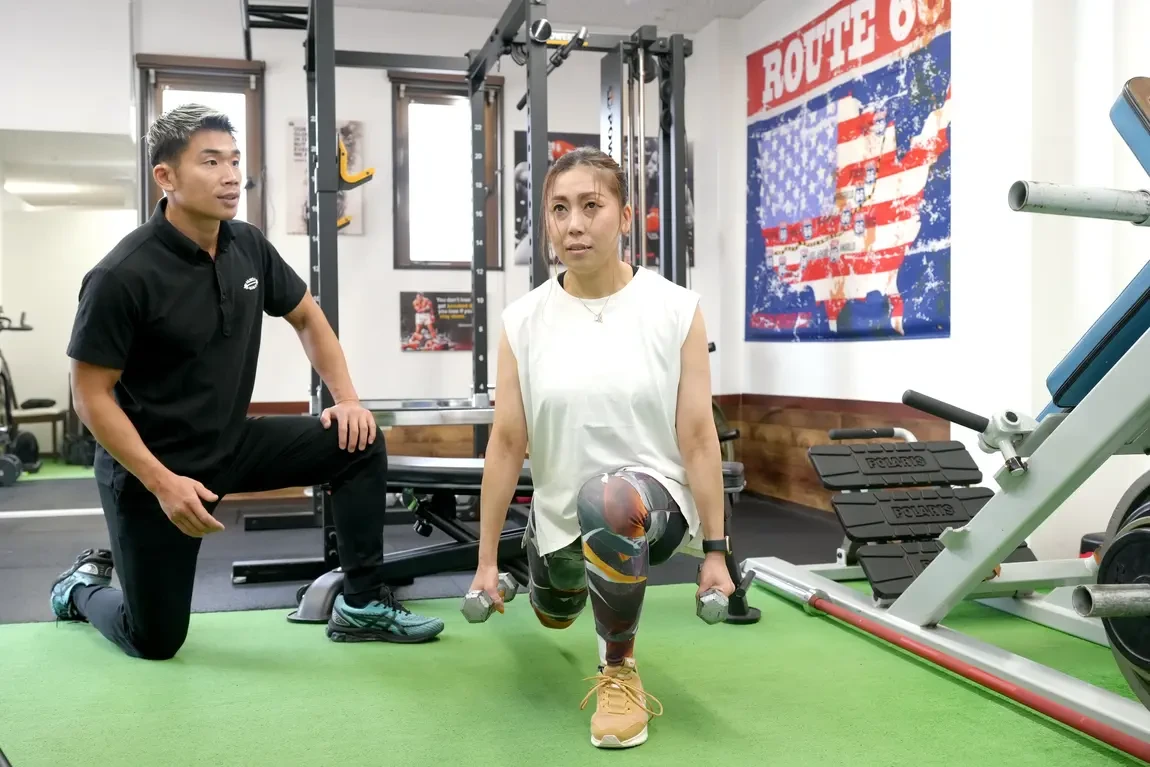 Muscle Quality草津店でトレーナーの指導を受けながらトレーニングする女性