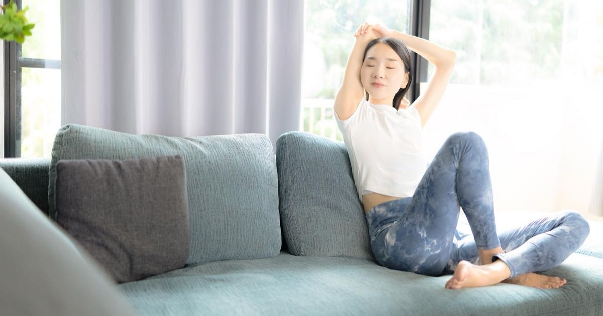 ソファで伸びをする女性|草津・南草津 女性が安心して通えるパーソナルジム